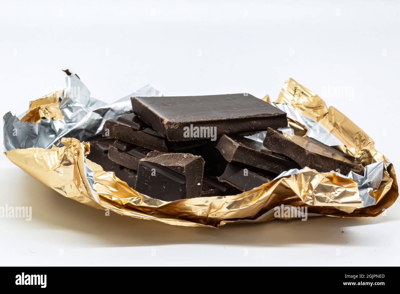 Ein Stapel zerbrochener dunkler Schokolade auf weißem Hintergrund Stockfoto