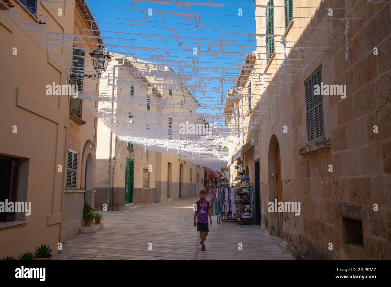 Ein Junge geht durch eine Seitenstraße von Alcúdia, Mallorca, Spanien Stockfoto