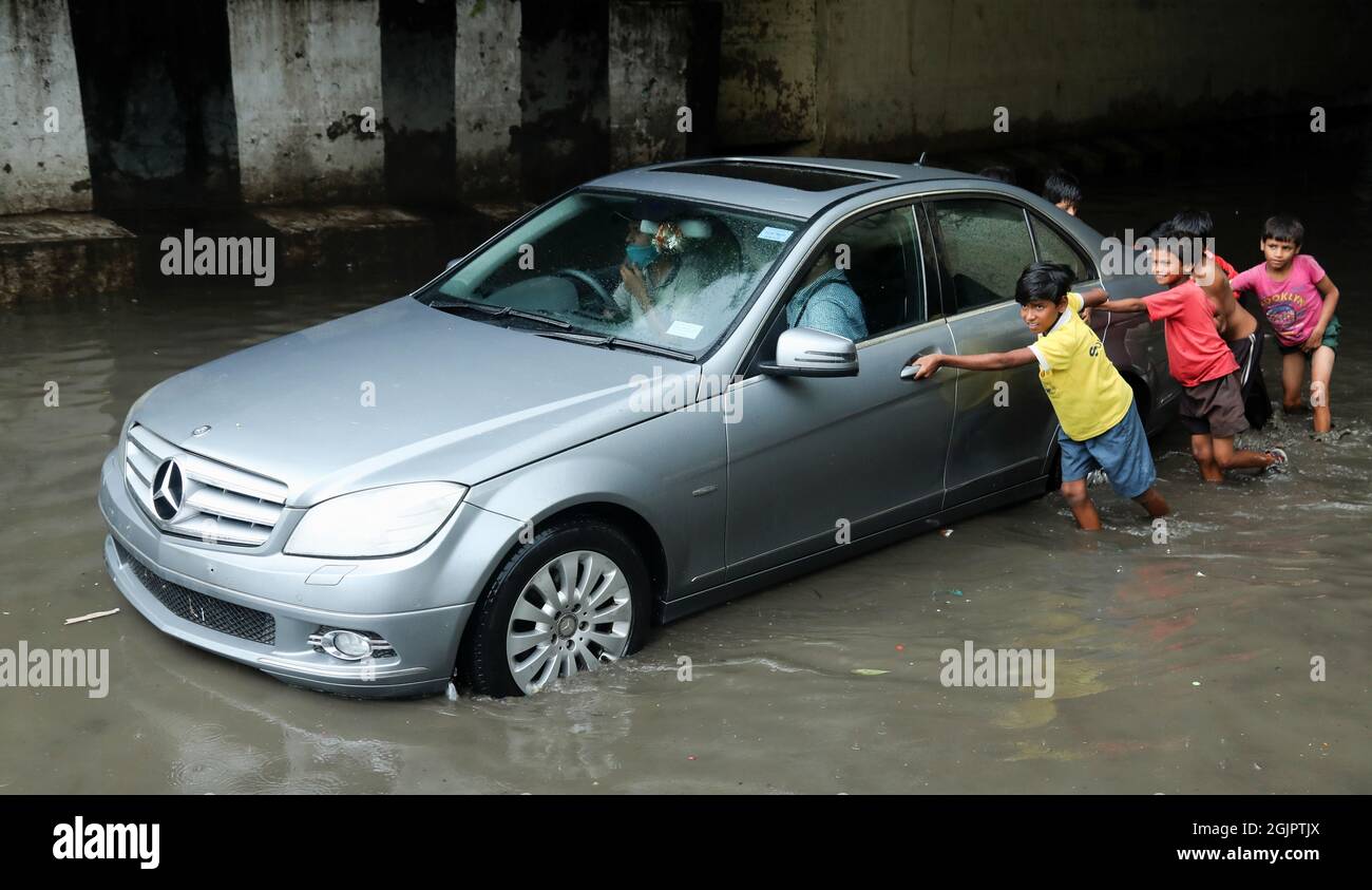 Neu-Delhi, Indien. September 2021. Die Kinder sahen, wie sie nach starken Regenfällen in Neu-Delhi ein Auto durch eine wasserverdrängte Zakhira-Unterführung schob. Die Verkehrspolizei von Delhi schloss mehrere Unterführungen und Straßen, um den Verkehr aufgrund von starken Regenfällen und Wassereinschlägen in vielen Gebieten zu vermeiden, darunter auch dem internationalen Flughafen Indira Gandhi. Das Indian Meteorological Department (IMD) kündigte Gewitter mit sehr starken Regenfällen in der Hauptstadt an. Kredit: SOPA Images Limited/Alamy Live Nachrichten Stockfoto