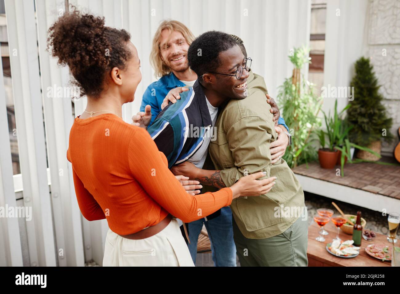 Multiethnische Gruppe moderner junger Freunde, die sich bei einer Dachparty begrüßen, Platz kopieren Stockfoto