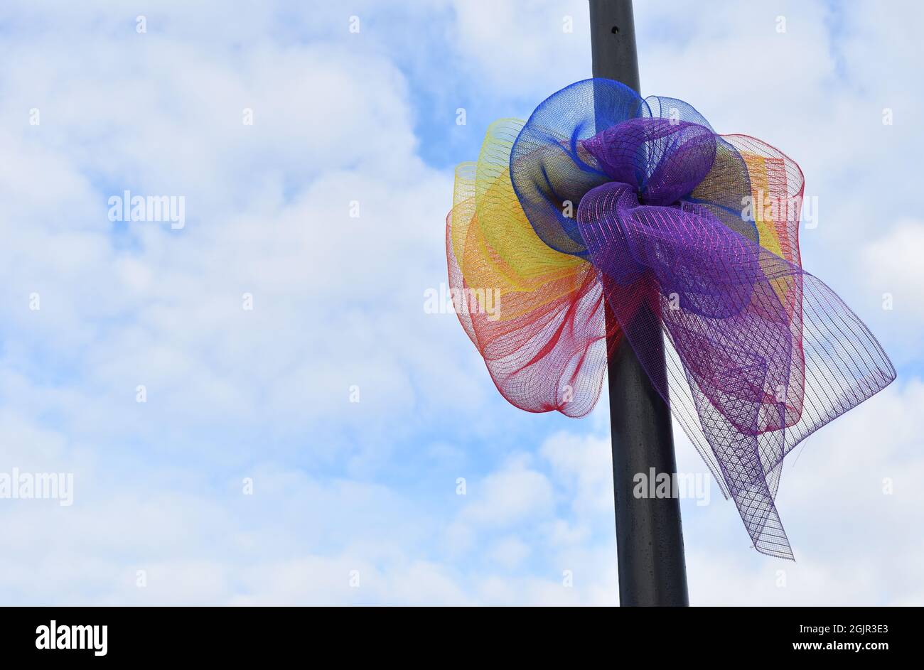 Regenbogen-Streifen mit Copyspace zum MK Pride Festival 2021 auf dem Milton Keynes Station Square gegen den Himmel. Stockfoto