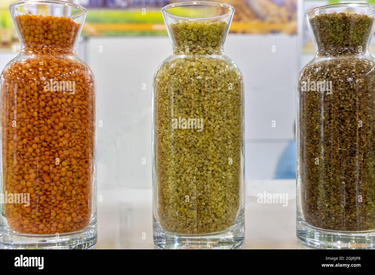 Verschiedene Hülsenfrüchte und Getreide in Glasflaschen Stockfoto