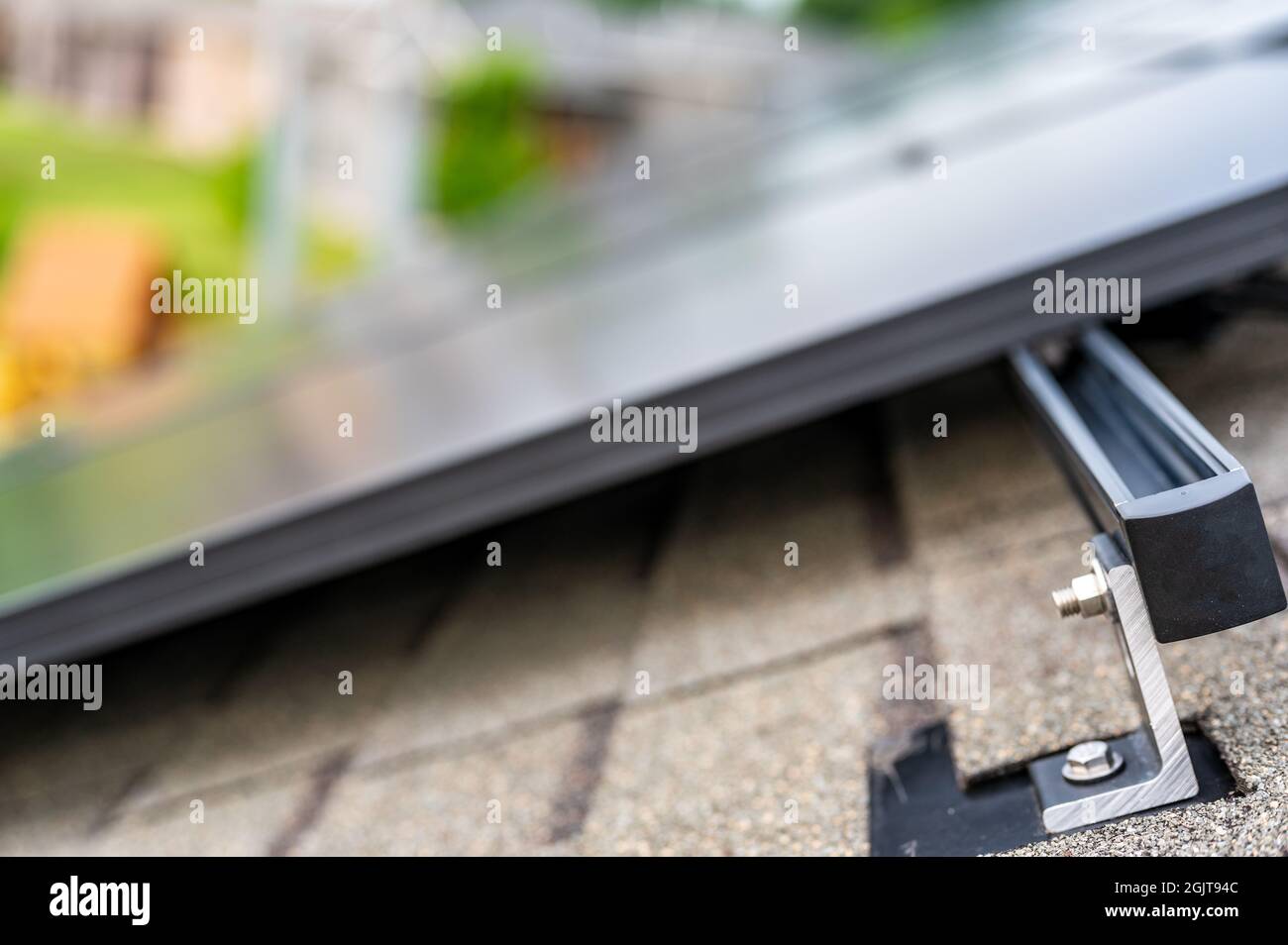 Schiene, Halterung und Anker an einem Solarpanel, das auf einem Asphaltschindeldach installiert ist Stockfoto