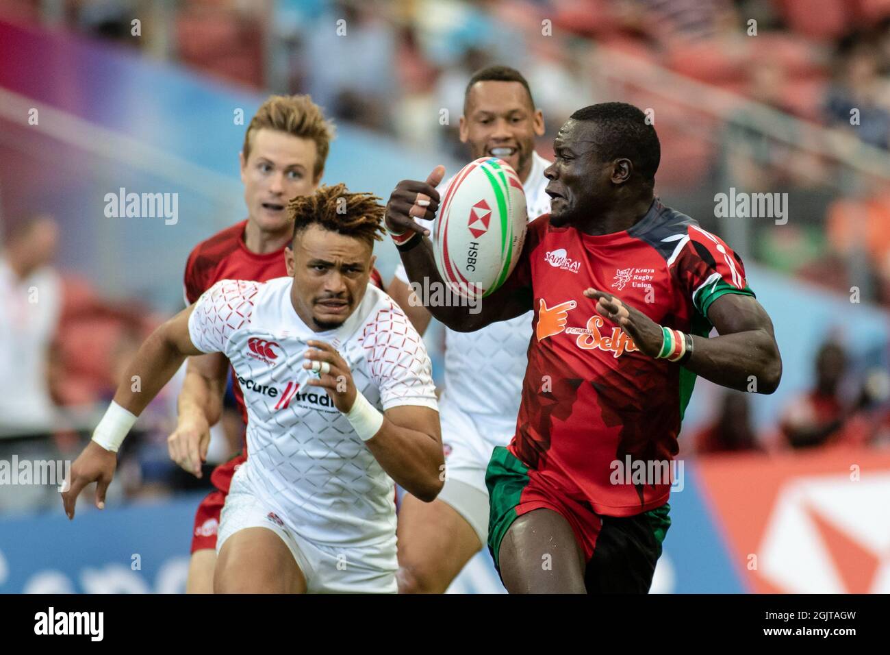 SINGAPUR-13. APRIL: Das Kenya 7s Team (rot) spielt am 1. Tag des HSBC World Rugby Singapore Sevens am 13. April 2019 im Nationalstadion in Singapur gegen das England 7s Team (weiß) Stockfoto