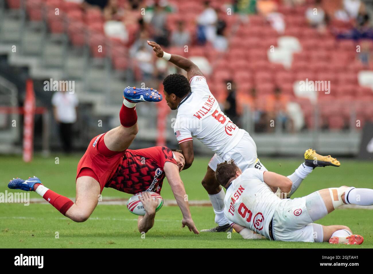 SINGAPUR-13. APRIL: Das Wales 7s Team (rot) spielt am 1. Tag des HSBC World Rugby Singapore Sevens am 13. April 2019 im Nationalstadion in Singapur gegen das USA 7s Team (weiß) Stockfoto