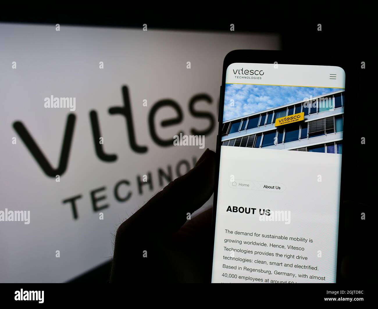 Person mit Smartphone und Webseite des deutschen Automobilzulieferers Vitesco Technologies auf dem Bildschirm mit Logo. Konzentrieren Sie sich auf die Mitte des Telefondisplays. Stockfoto
