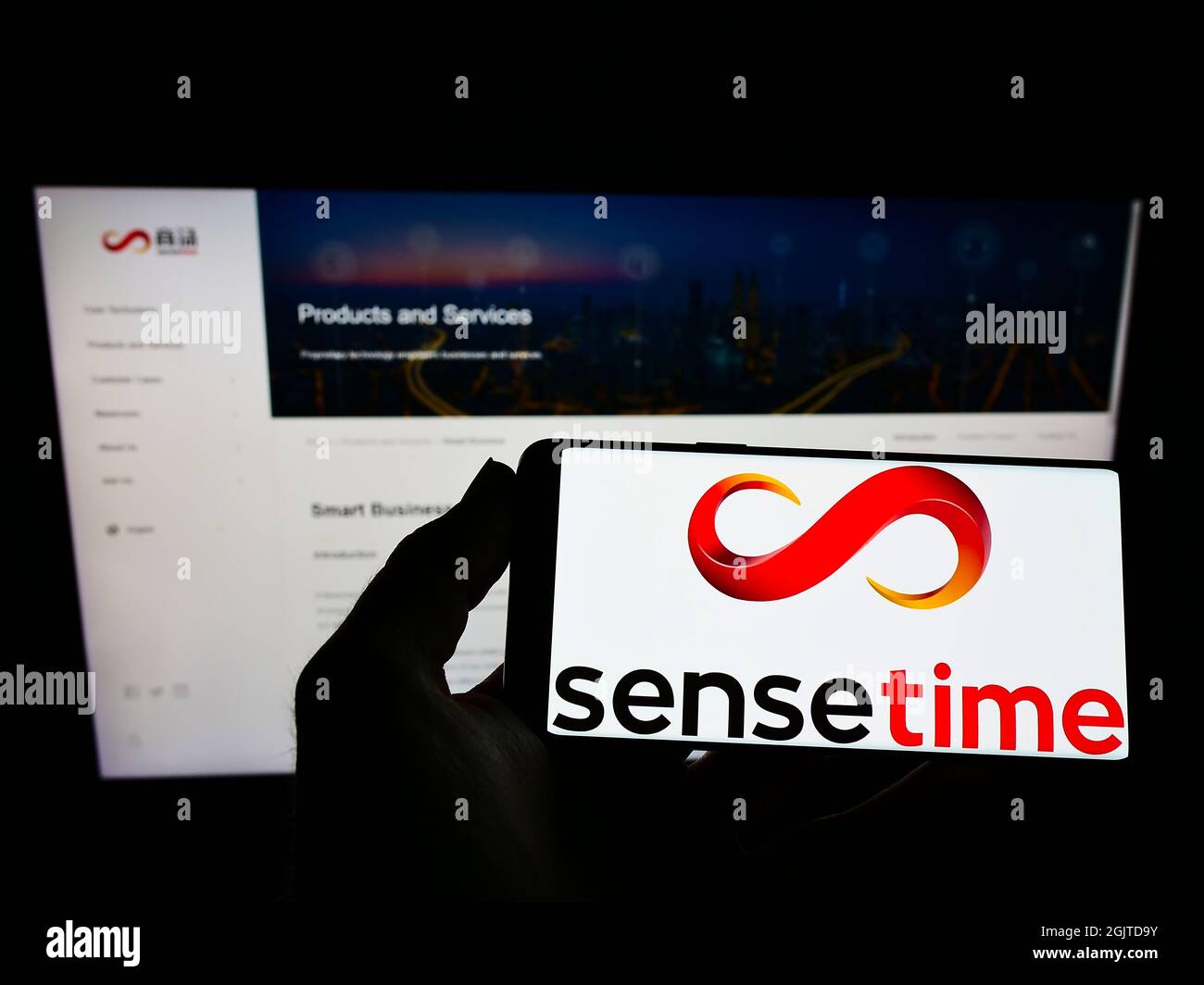 Person, die Mobiltelefon mit dem Logo des chinesischen Unternehmens für künstliche Intelligenz SenseTime auf dem Bildschirm vor der Webseite hält. Konzentrieren Sie sich auf die Telefonanzeige. Stockfoto