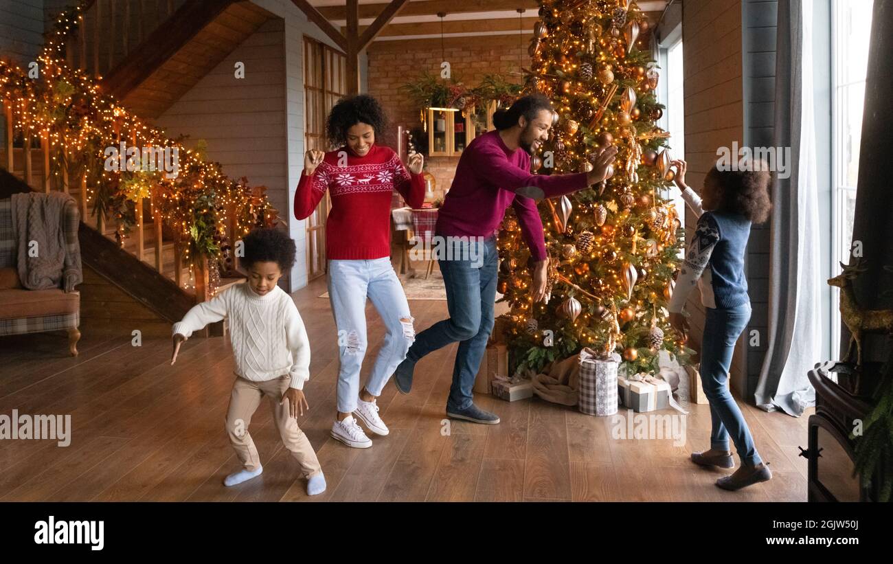 Glückliche Biracial Familie mit Kindern tanzen in der Nähe von Tannenbaum Stockfoto