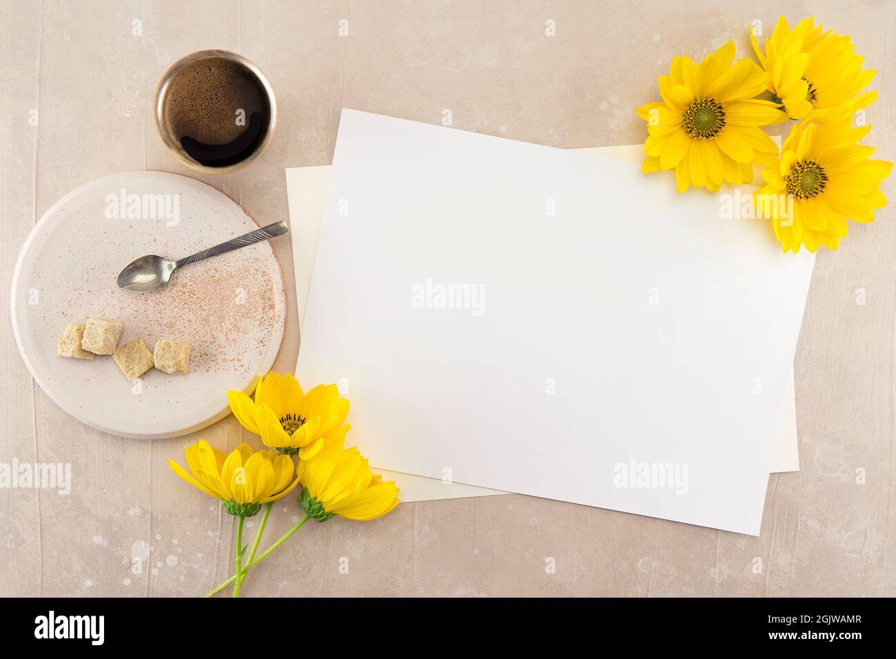 Leere weiße Hochzeit oder Grußkarte Mockup auf rosa vintage Tisch Hintergrund, Web-Banner für Design mit großen gelben Blumen, Tasse Kaffee, Teller mit Stockfoto
