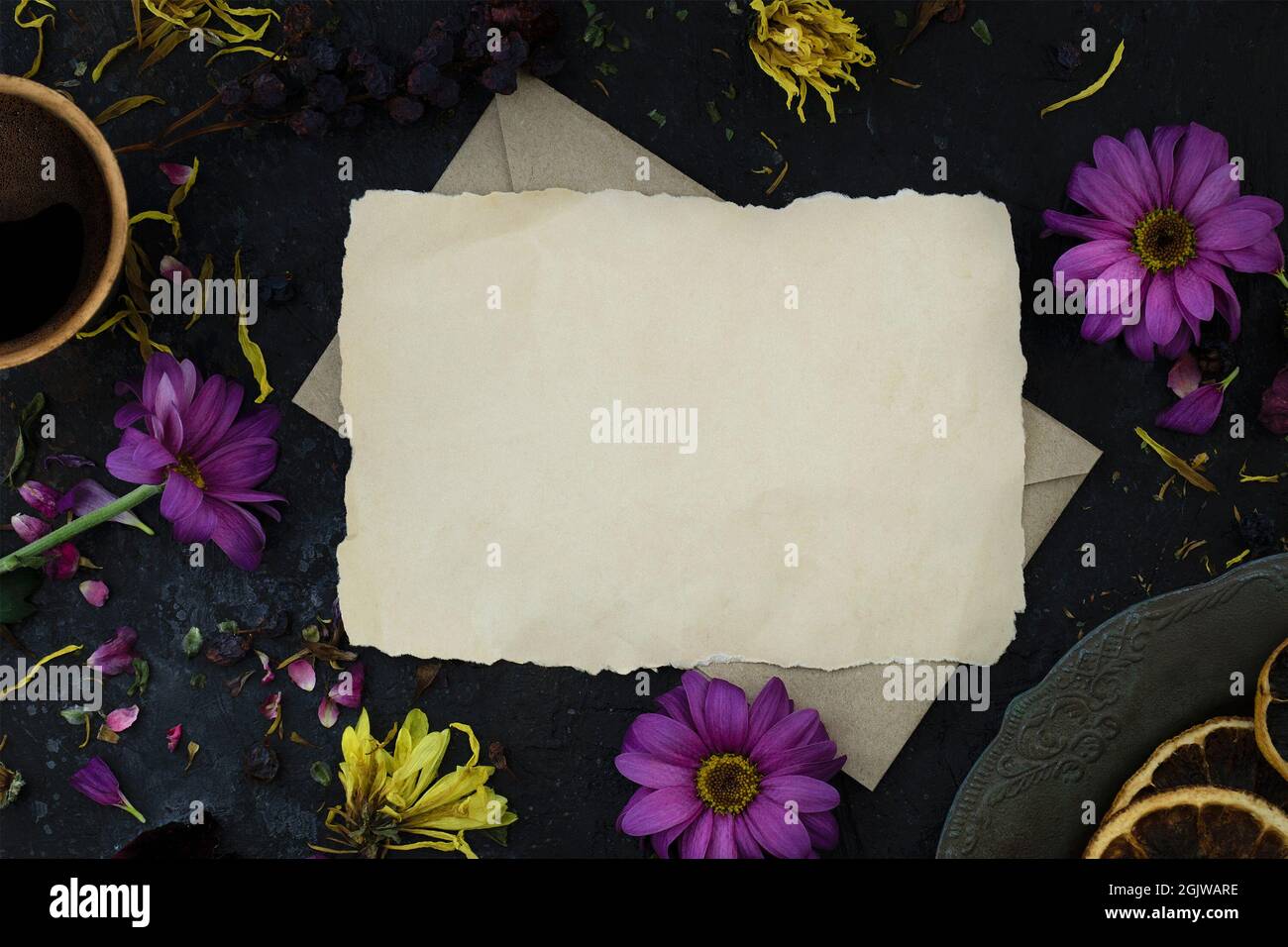 Nachbau eines Briefes auf einem Umschlag zwischen welken Blumen, einer Tasse Kaffee und einem Vintage-Teller. Draufsicht. Melodische Stimmung Stockfoto