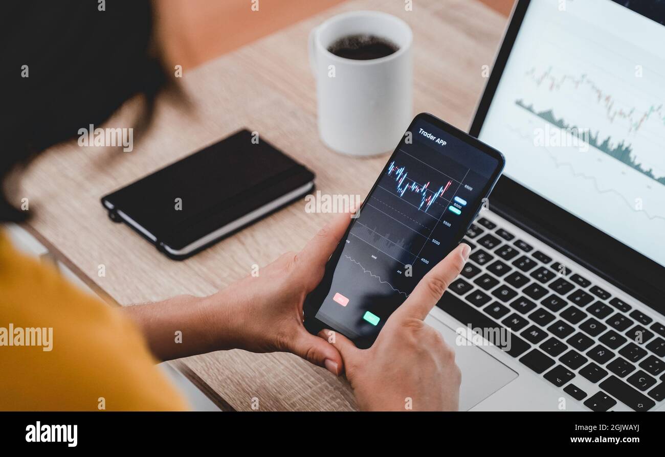 Trader Business Woman mit Trading Stock Market Exchange App - Bitcoin, Global Economy Concept - Fokus auf Hände halten Handy Stockfoto