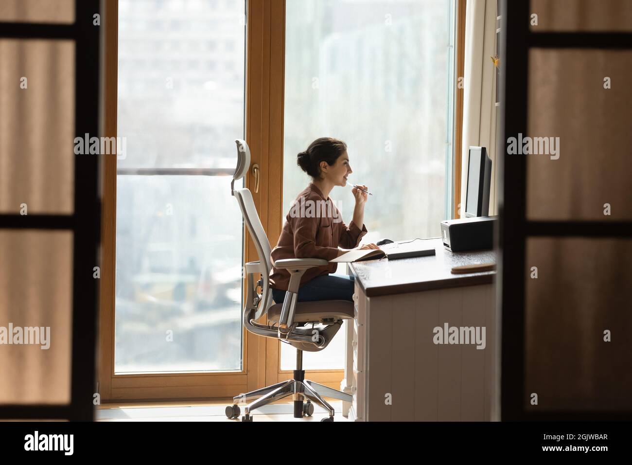 Indische Frau sitzen am Arbeitsplatz auf ergonomischen Stuhl verwenden pc Stockfoto