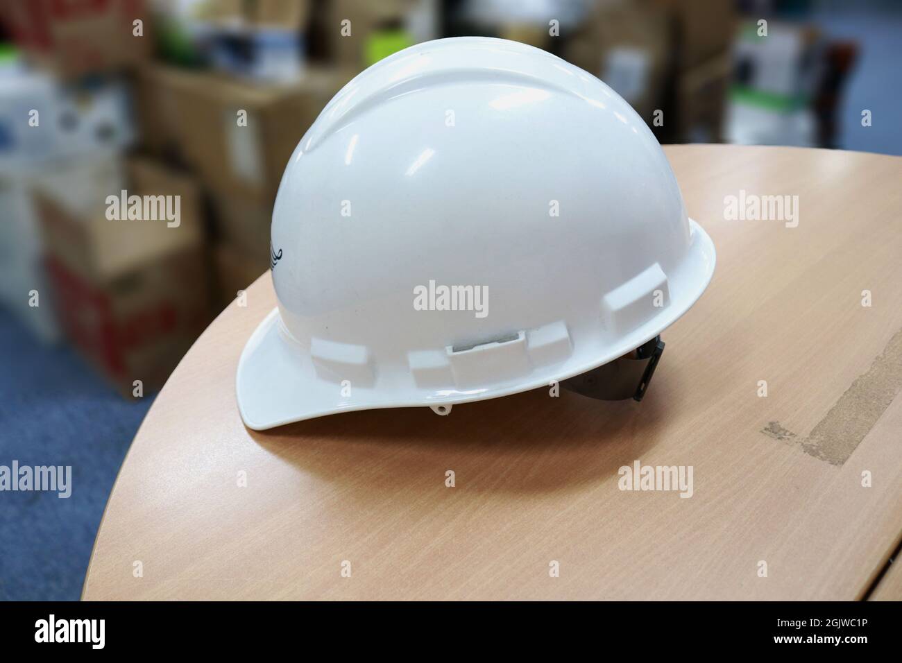 Ein weißer Schutzhelm zum Schutz der Köpfe der Arbeiter vor Arbeitsunfällen, wie Kollisionen mit harten Gegenständen, sind Helme eine Anforderung an die Sicherheit zuerst Stockfoto