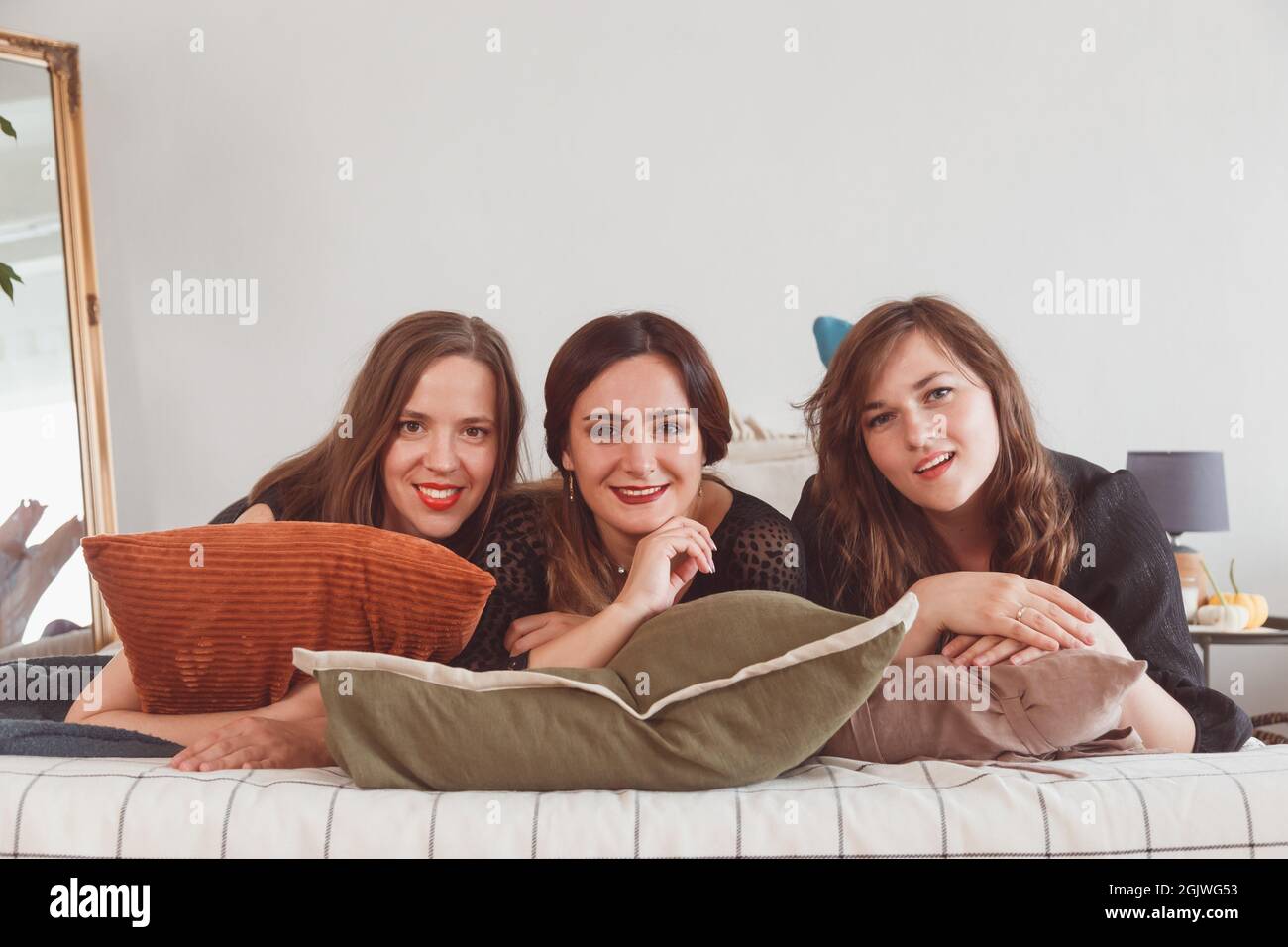 Pyjama-Party, Frauen liegen auf dem Bett, Unterhaltungskonzept. Stockfoto