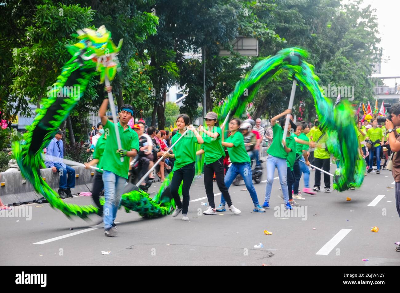 Die Jugendlichen spielen den liong oder Drachen mit langen Stöcken, während sie am Cap Go Meh Karneval teilnehmen. Stockfoto