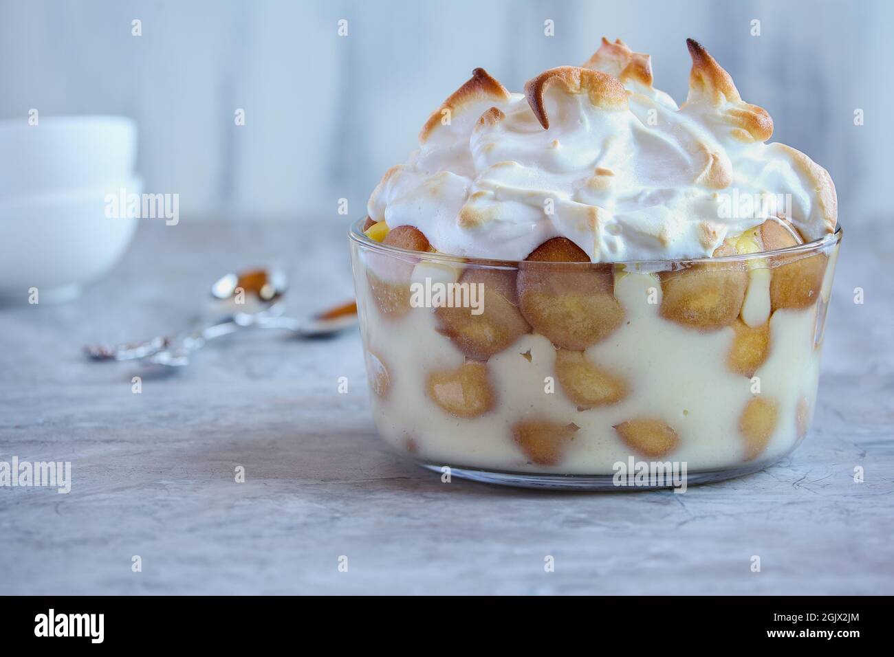 Frisch zubereitetes, hausgemachtes Bananenpudding aus dem nichts für die Feiertage. Mit Waffeln und Baiser in Lagen. Selektiver Fokus mit unscharfem Hintergrund. Stockfoto