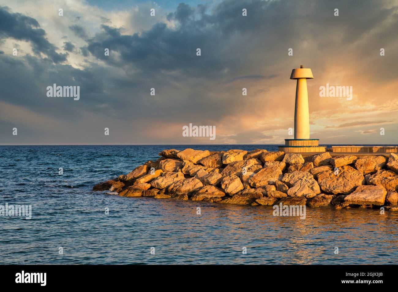 Leuchtturm von Ayia Napa bei Sonnenuntergang, Zypern. Horizont und dramatischer Himmel. Stockfoto