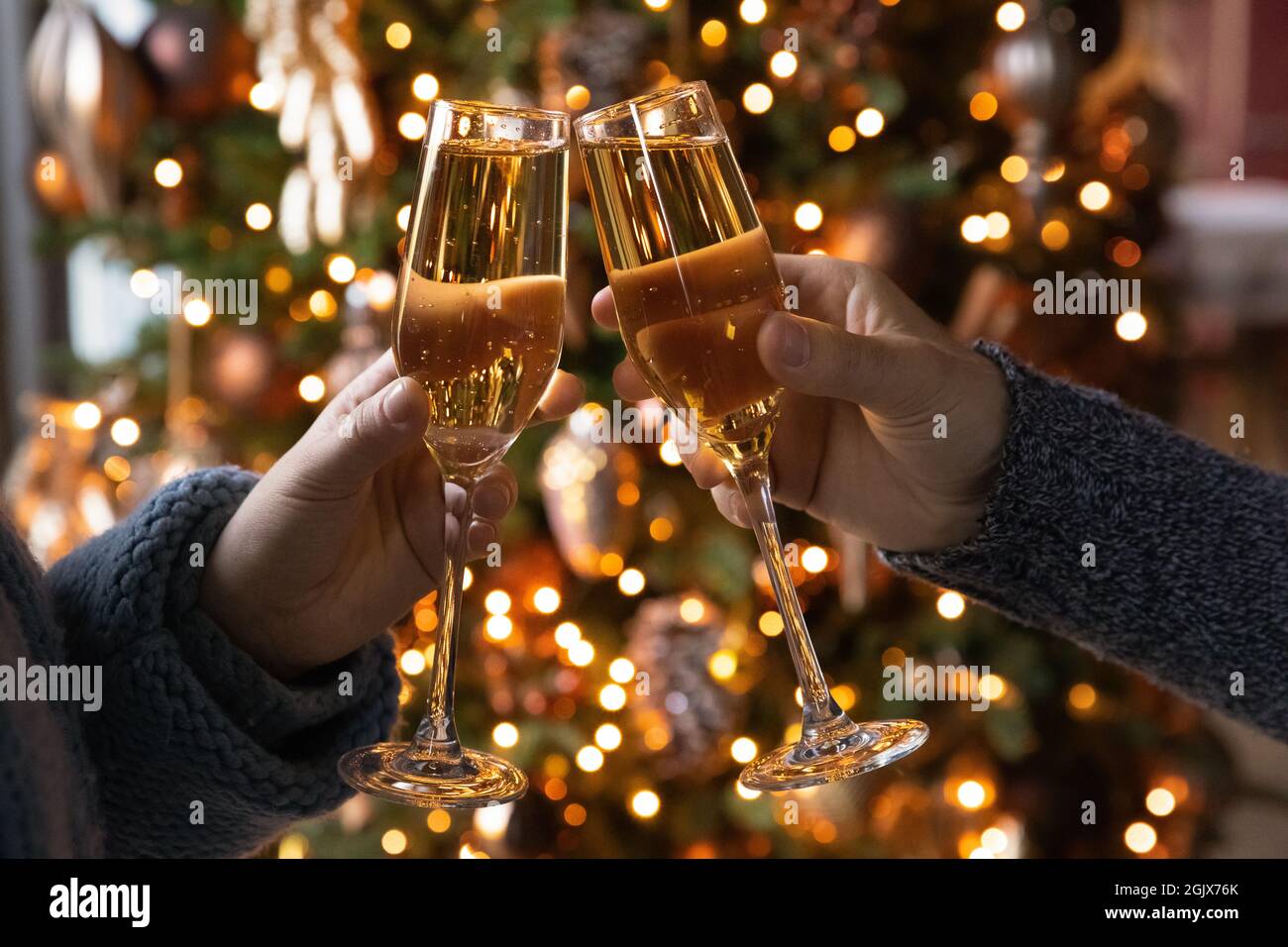 Nahaufnahme Junges Paar klirrende Gläser mit Champagner, Neujahr Feier. Stockfoto
