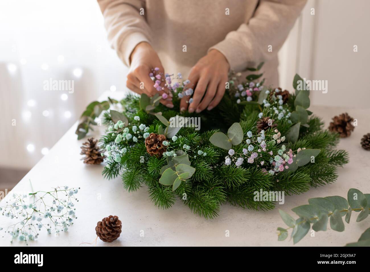 Person Hände machen Weihnachtskranz Stockfoto