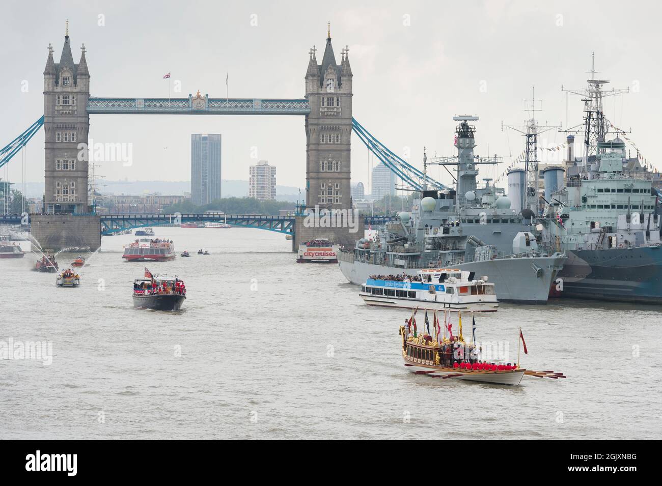 Royal River Salute, um die Königin zu markieren, die zum längsten regierenden Monarchen in der britischen Geschichte wurde, angeführt von Royal Barge 'Gloriana'. Die Prozession ist Teil der Totally Thames Celebration, einer einmonatigen Saison mit Veranstaltungen im Zusammenhang mit dem Fluss, die den ganzen September über stattfinden. Die ‘Gloriana’ wurde auf ihrer Reise von der Tower Bridge zum Palace of Westminster mit dem Feuerwehrboot „Massey Shaw“ begleitet. Die ‘Gloriana’ kam an dem HMS Belfast WW2 Cruiser vorbei, an dem die Fregatte HMS Portland festmachen musste. Tower Bridge, London, Großbritannien. 9. September 2015 Stockfoto