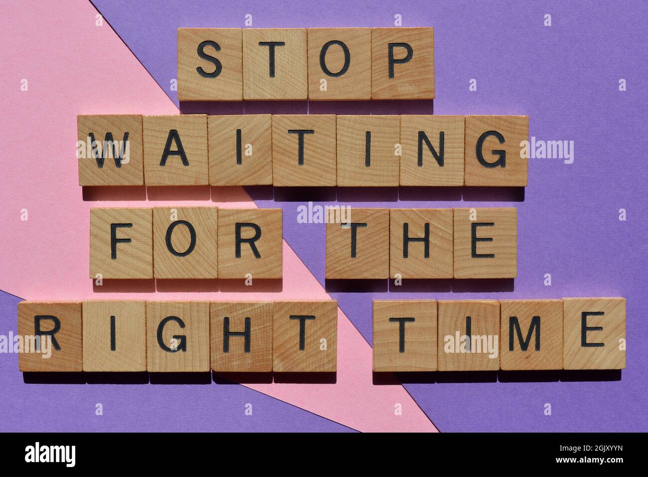 Hören Sie auf, auf die richtige Zeit zu warten, Wörter in Holzbuchstaben, isoliert auf dem Hintergrund Stockfoto