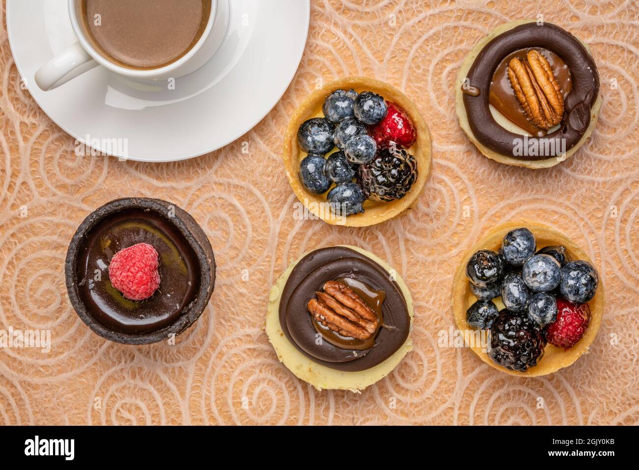 Obst und Nüsse Mini-Törtchen mit einer Tasse Kaffee, Dessert flach legen Stockfoto