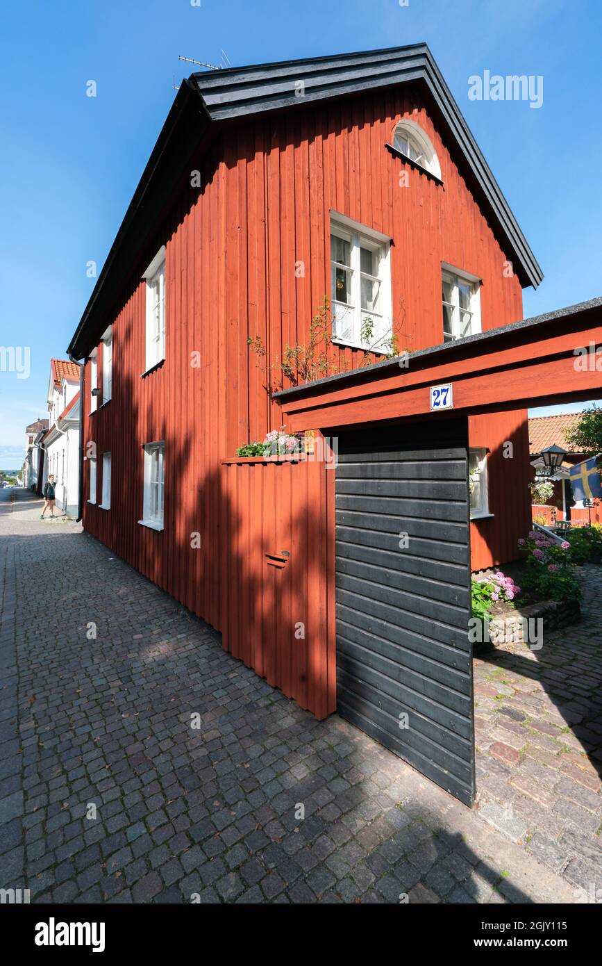 Vastervik, Schweden - 08.23.2021: Große vertikale Aufnahme eines alten, traditionellen roten Holzhauses im skandinavischen Stil. Sonniger Sommertag. Stockfoto