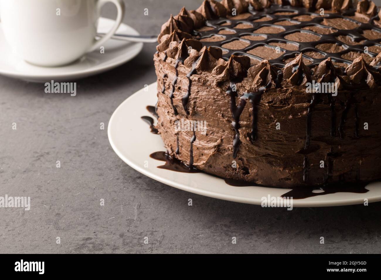Hausgemachte Schokoladenkuchen mit beträufter Schokolade auf grauem Hintergrund Stockfoto
