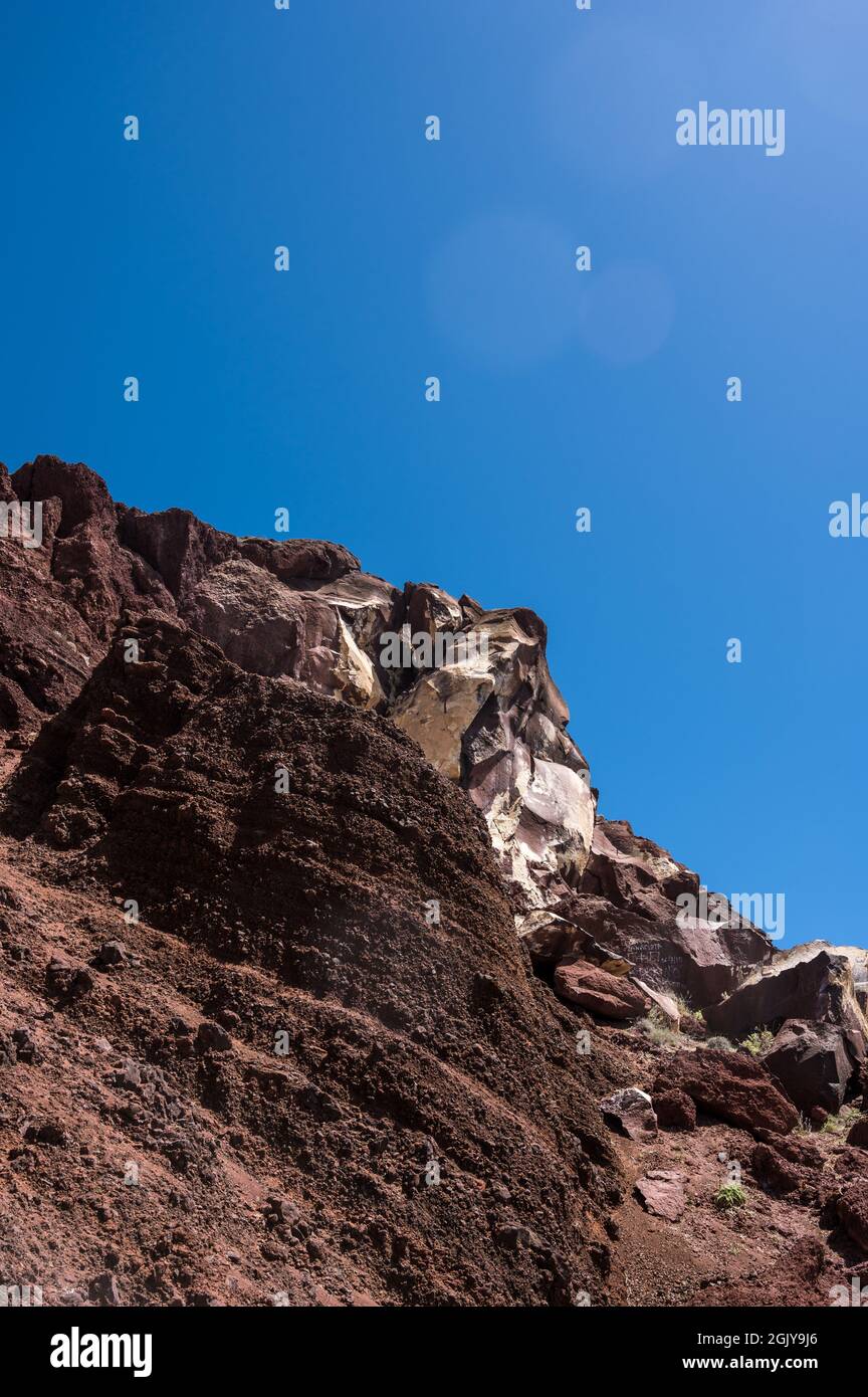 Riesige rote Felsklippe am roten Sandstrand von Santorini. Fremde Landschaft. Stockfoto