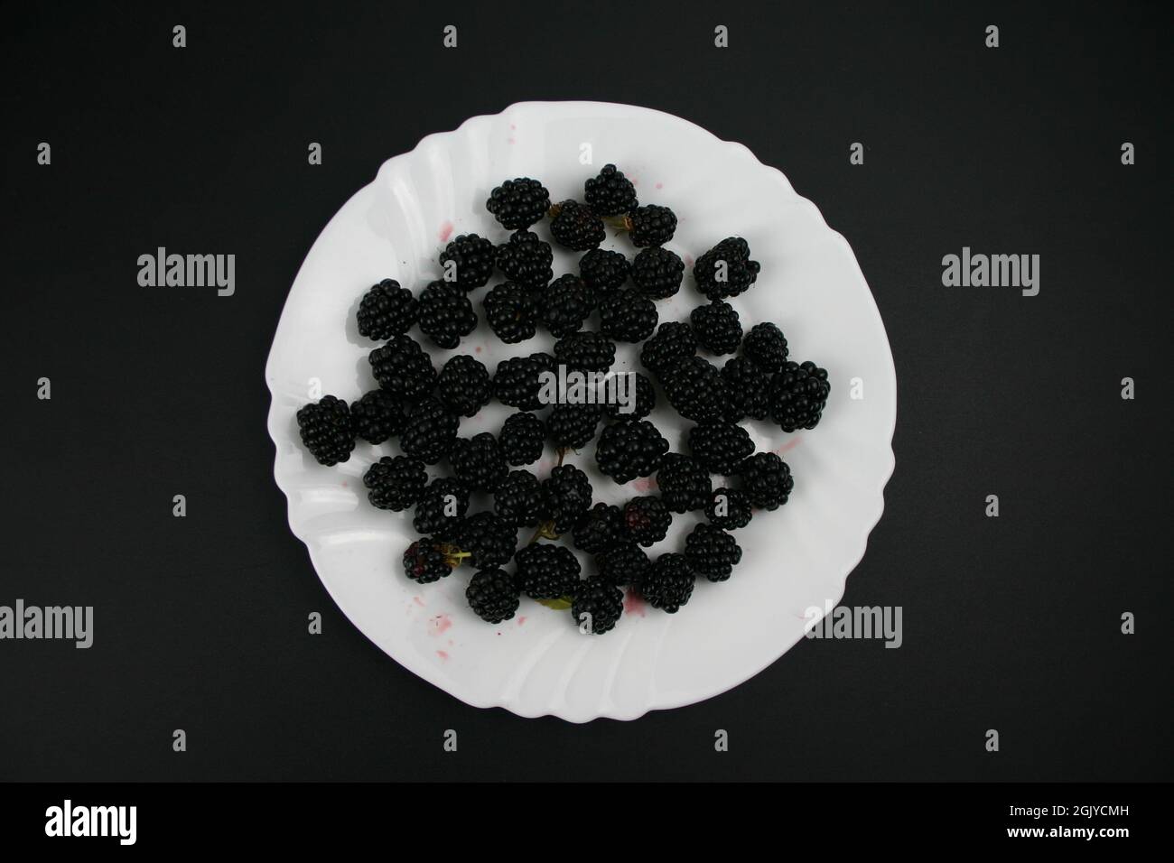Nahaufnahmen weißer Teller mit Bio Obst Brombeeren Stockfoto