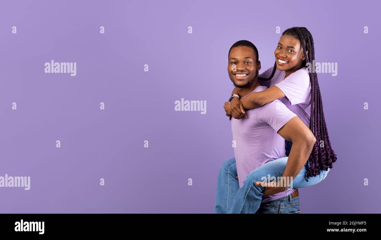 Afroamerikanischer Mann, der für seine Dame Huckepack-Fahrt gab Stockfoto