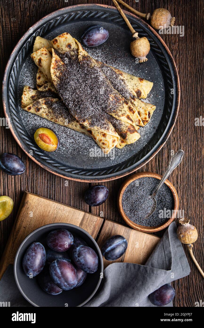 Lokse, traditionelles slowakisches Kartoffel-Fladenbrot mit Pflaumenmarmelade und Mohnfüllung auf Holzboden Stockfoto