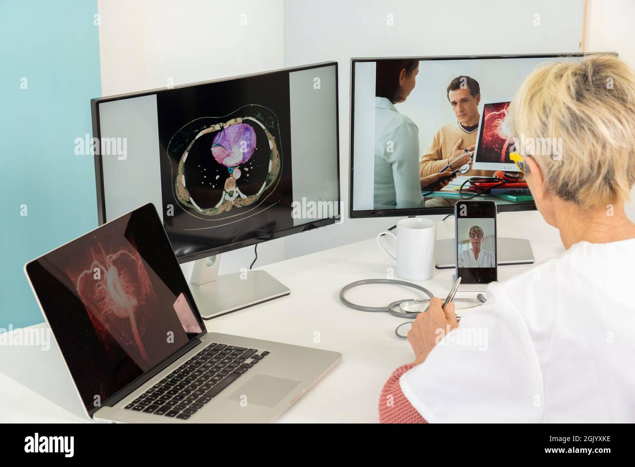 Telekonsultation zwischen zwei Ärzten mit medizinischen Bildern von Mägen auf einem der Bildschirme. Stockfoto