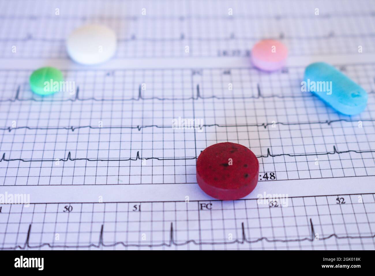 Medikamente auf einem EKG. Arzttisch. Konzept für Gesundheit und Krankheit nach einer Pandemie. Selektiver Fokus. Stockfoto