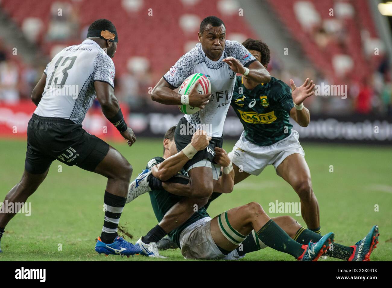 SINGAPUR-APRIL 14: Fidschi-7s-Team (weiß spielt gegen südafrikanische 7s-Team (grün) während des Cup-Finalspiels von HSBC World Rugby Singapore Sevens am 14. April 2019 im Nationalstadion in Singapur Stockfoto
