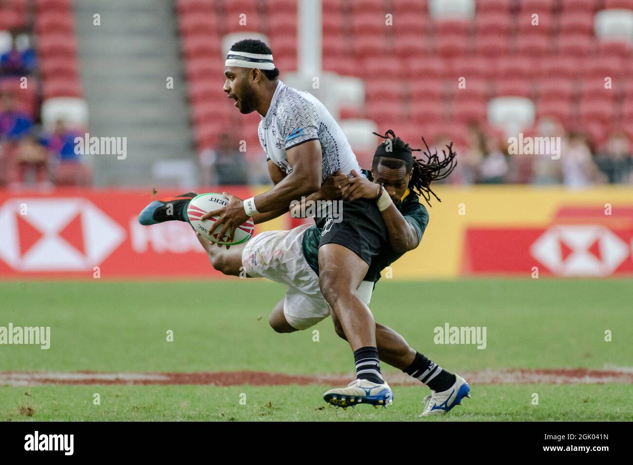SINGAPUR-APRIL 14: Fidschi-7s-Team (weiß spielt gegen südafrikanische 7s-Team (grün) während des Cup-Finalspiels von HSBC World Rugby Singapore Sevens am 14. April 2019 im Nationalstadion in Singapur Stockfoto