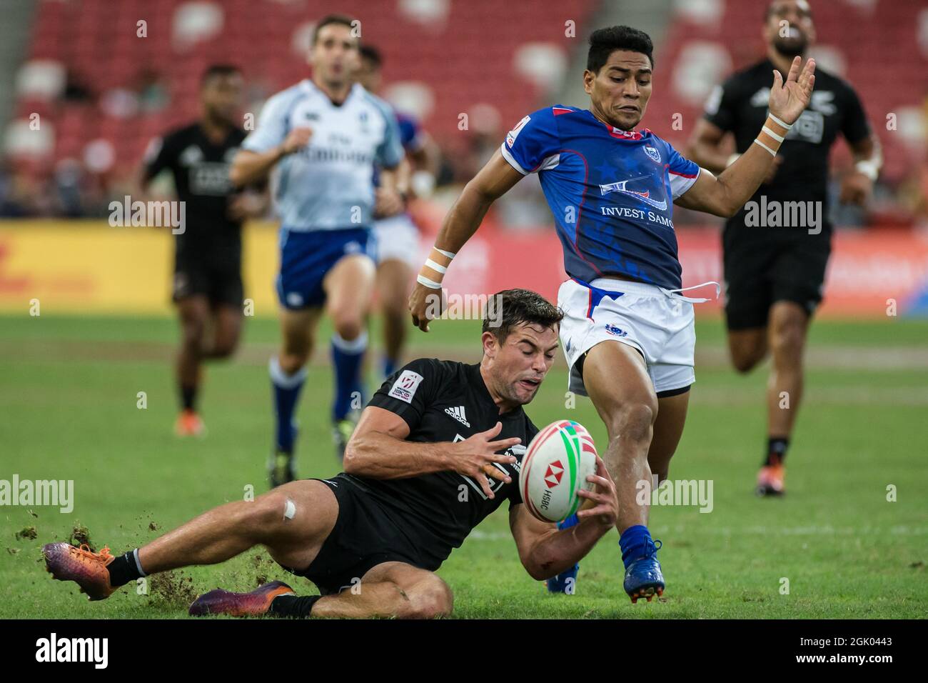 SINGAPUR-14. APRIL: Andrew Knewstubb vom neuseeländischen 7er Team (links/schwarz) spielt am 2. Tag des HSBC World Rugby Singapore Sevens am 14. April 2019 im Nationalstadion in Singapur gegen einen Samoa 7er-Mannschaftsspieler (blau) Stockfoto