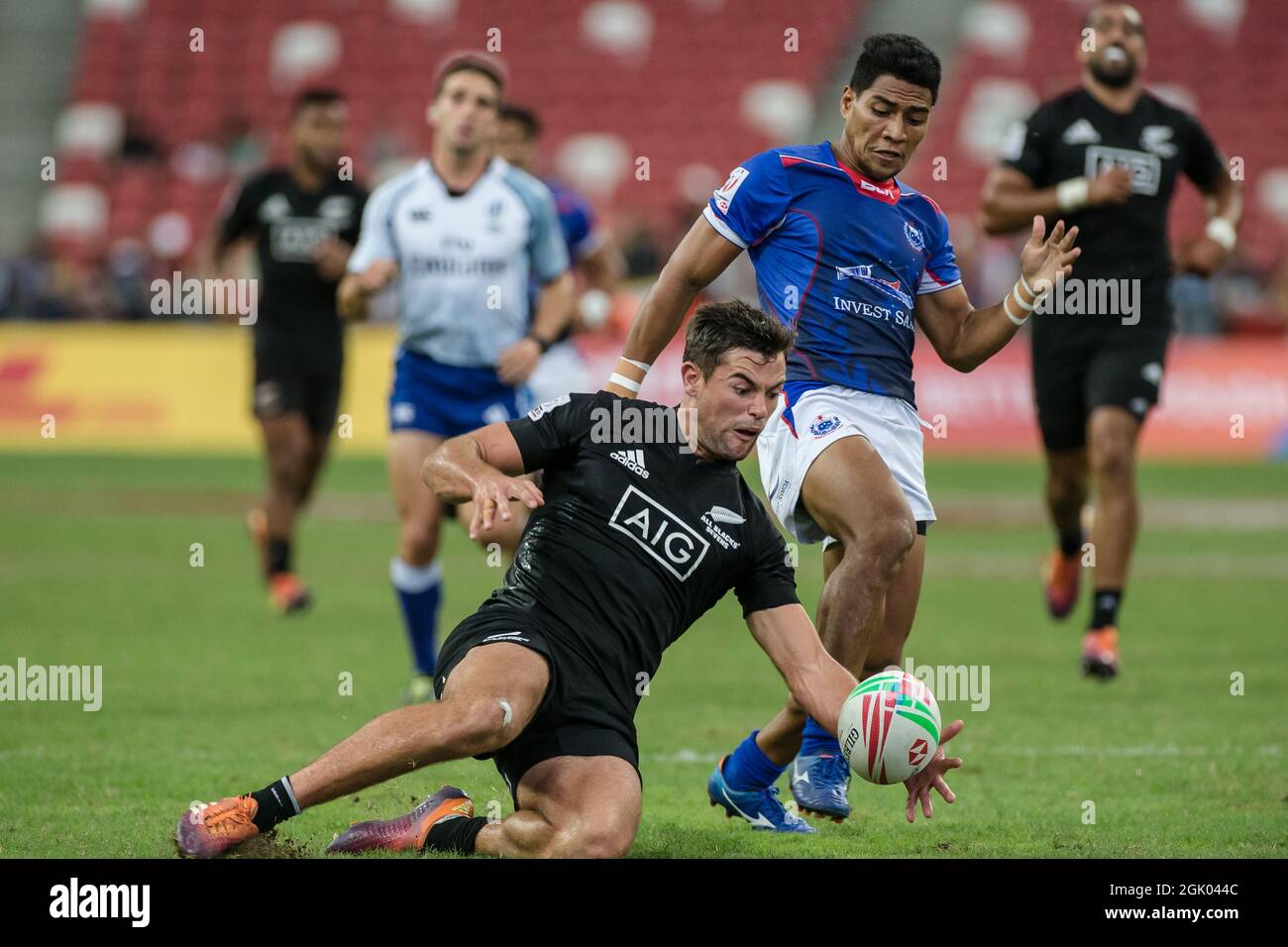 SINGAPUR-14. APRIL: Andrew Knewstubb vom neuseeländischen 7er Team (links/schwarz) spielt am 2. Tag des HSBC World Rugby Singapore Sevens am 14. April 2019 im Nationalstadion in Singapur gegen einen Samoa 7er-Mannschaftsspieler (blau) Stockfoto