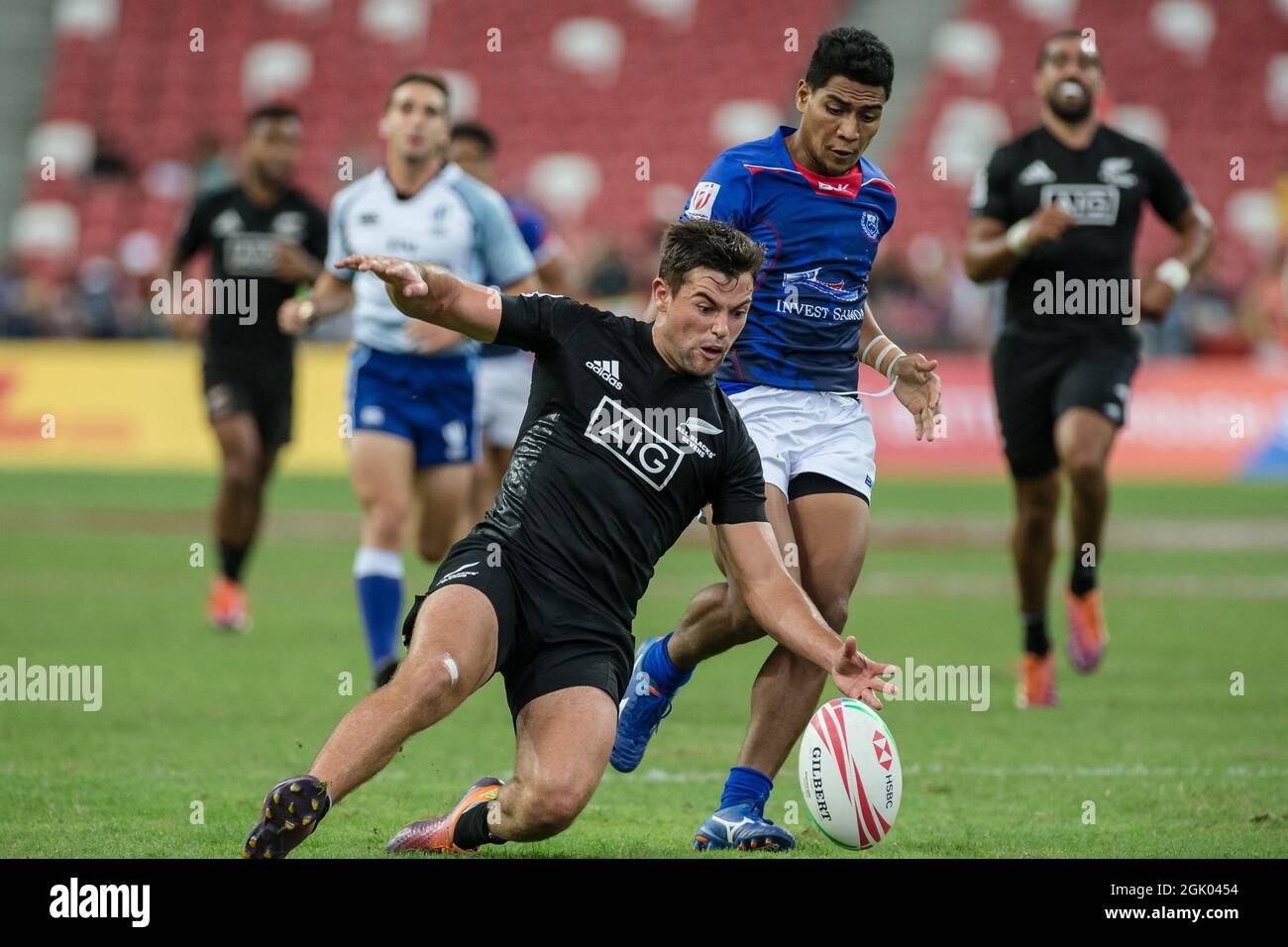 SINGAPUR-14. APRIL: Andrew Knewstubb vom neuseeländischen 7er Team (links/schwarz) spielt am 2. Tag des HSBC World Rugby Singapore Sevens am 14. April 2019 im Nationalstadion in Singapur gegen einen Samoa 7er-Mannschaftsspieler (blau) Stockfoto