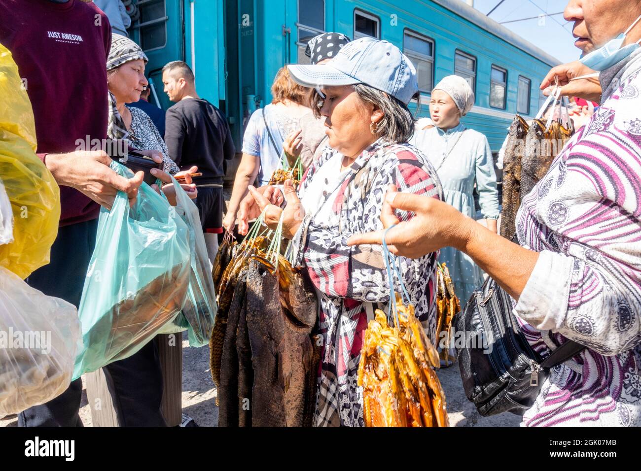 Frauen, die geräucherten Fisch auf der Haltestelle an die Zugpassagiere, Sary-Shagan Station, in der Nähe von Balkhash Lake, Kasachstan, Zentralasien, verkaufen Stockfoto