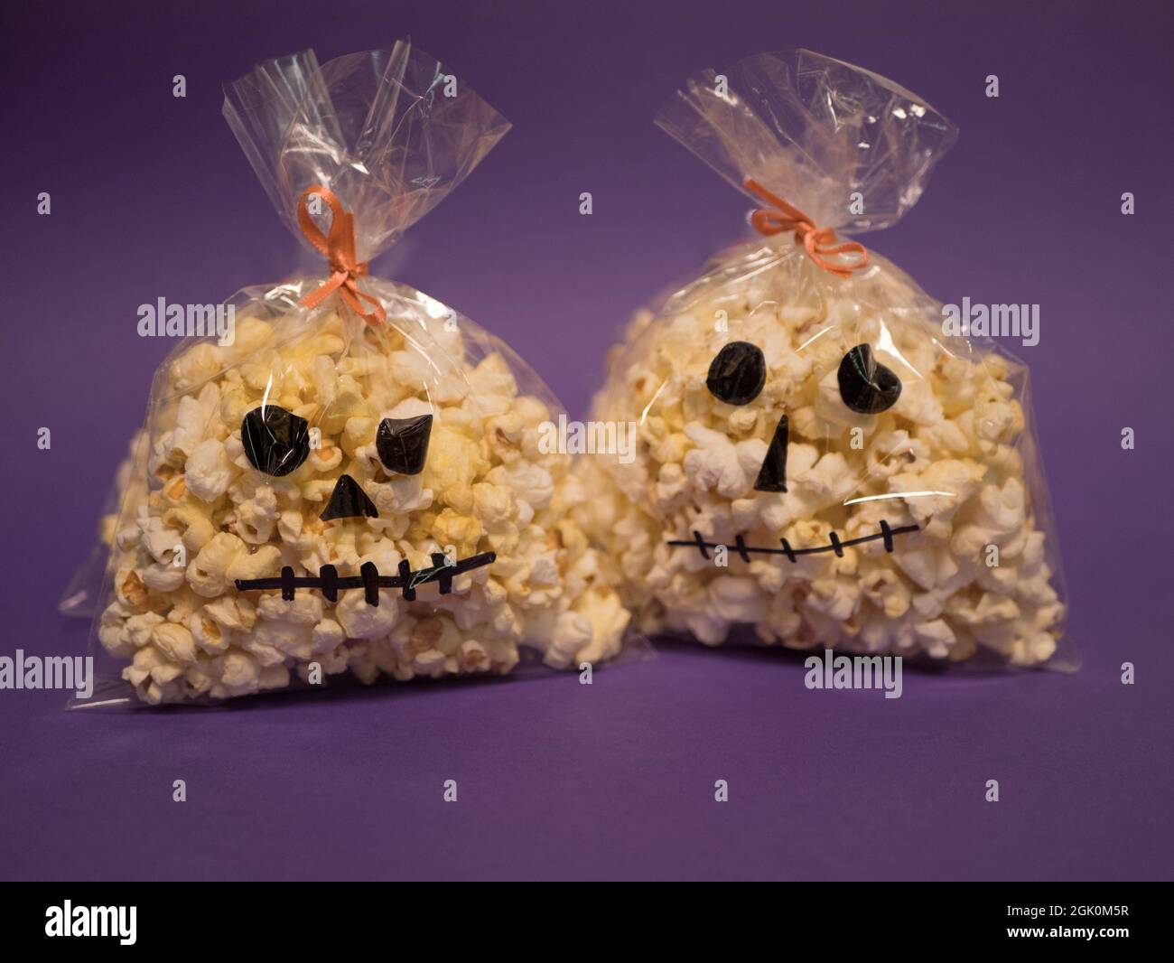 Tüten mit Popcorn in Form von Totenköpfen. Hausgemachte Halloween-Snacks Stockfoto