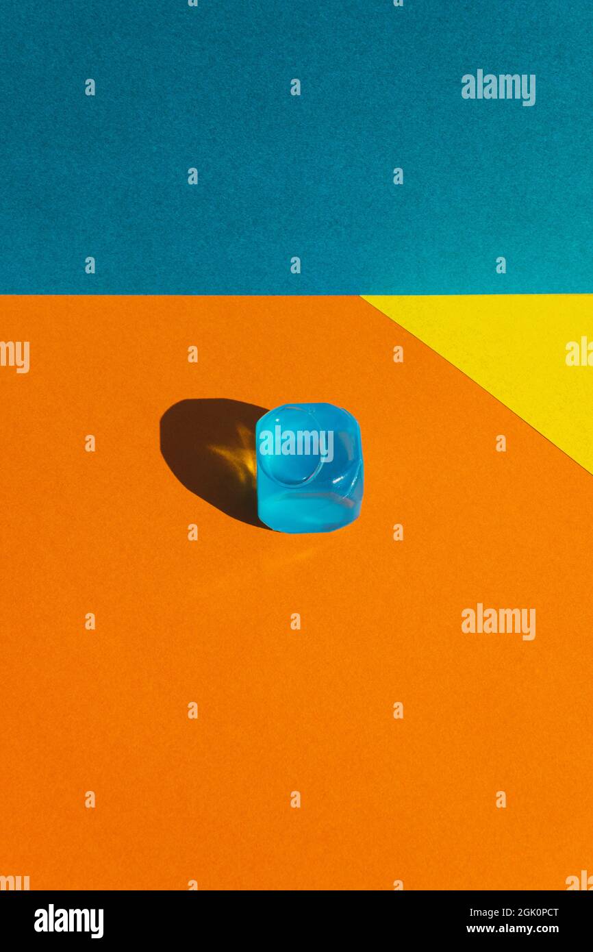 Kreatives Layout mit blauen Plastikwürfeln aus Eis in der Mittagssonne und harten Schatten im Hintergrund. Sommermockup. Flach liegend. Speicherplatz kopieren. Stockfoto