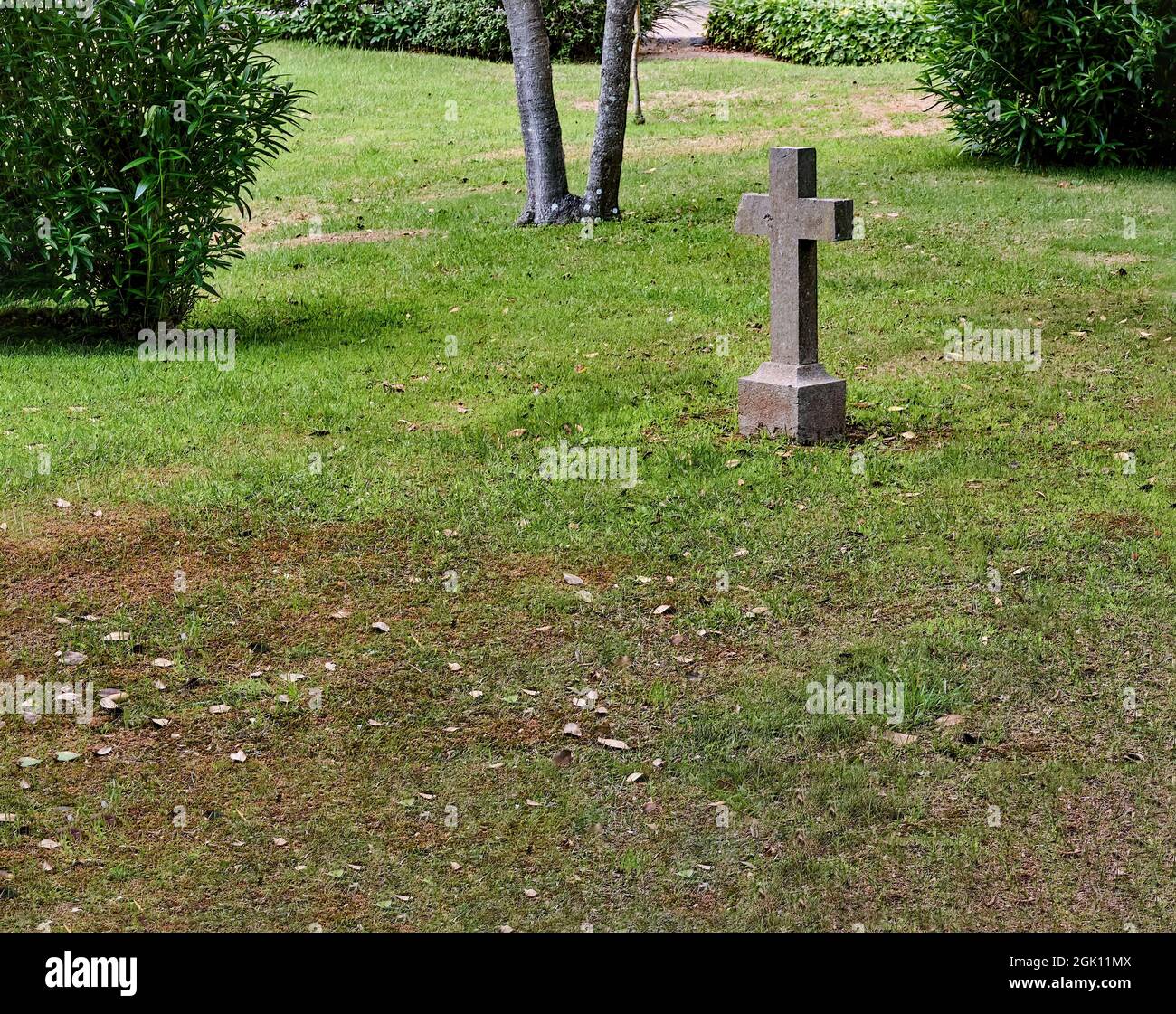 Friedhof, auf dem sich ein Grab ohne Namen befindet und in dem das Kreuz eine seiner Seiten gebrochen hat. Selektiver Fokus. Stockfoto