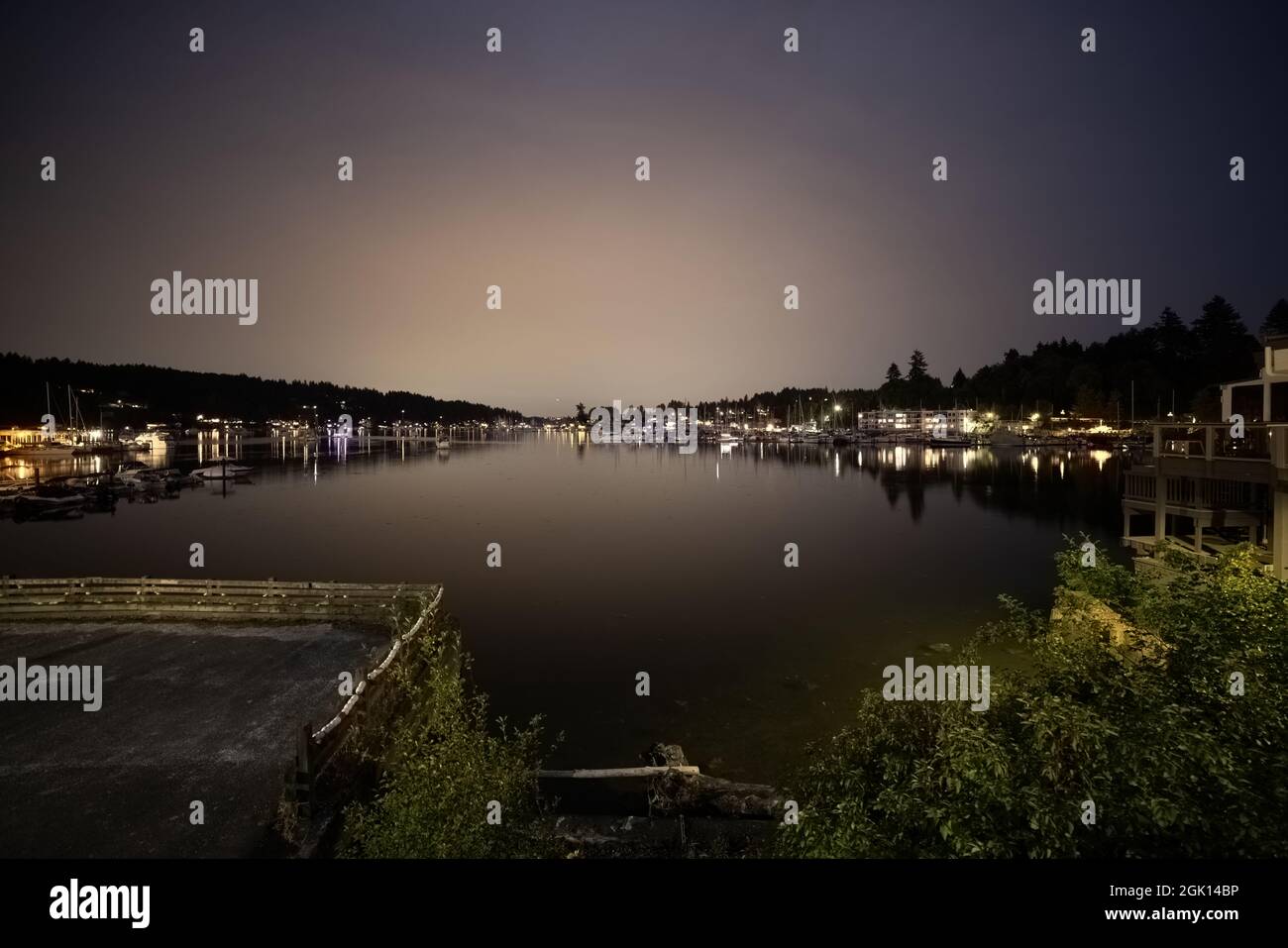 Nachtansicht des Hafens von Gig nach der blauen Stunde mit Booten, die auf dem Wasser glühen Stockfoto