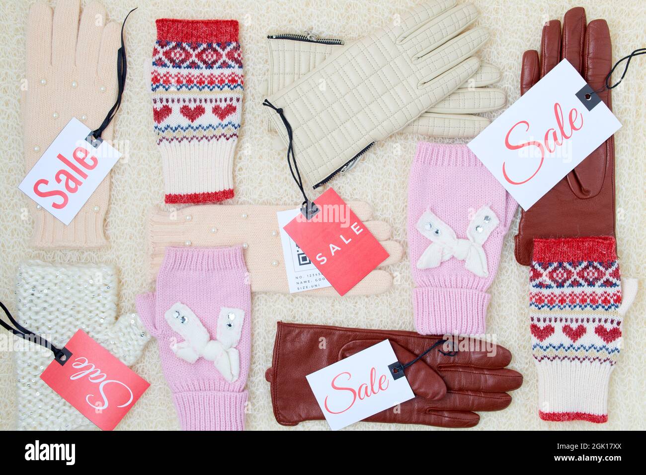 Winter flach Lay mit Fäustlingen, Handschuhe und Sale-Tag auf weißem gestrickten Hintergrund. Stockfoto