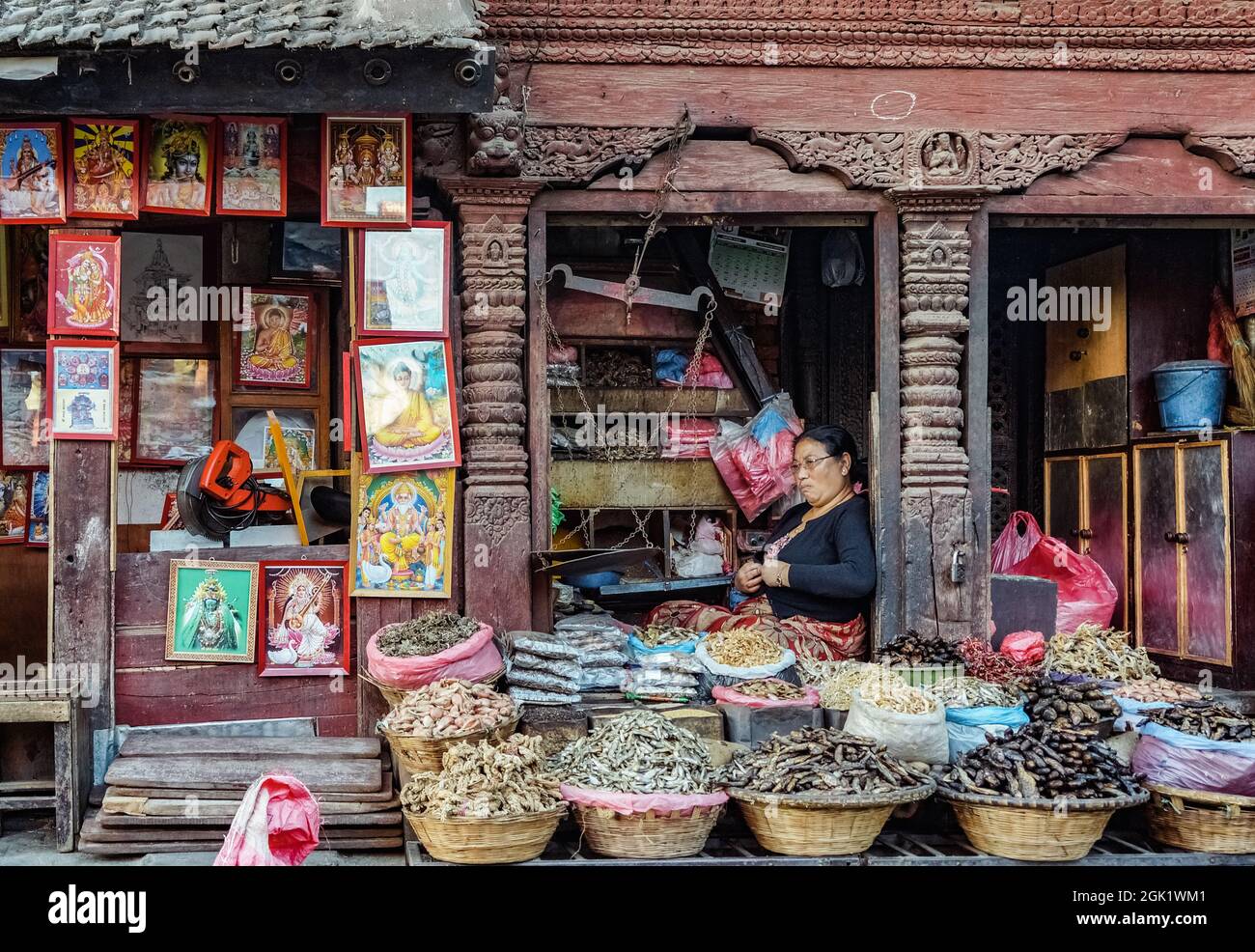 nepalesische Frau mittleren Alters, die Gewürze in einem traditionellen Lebensmittelgeschäft auf dem Markt in Kathmandu neben dem Durbar Square verkauft Stockfoto
