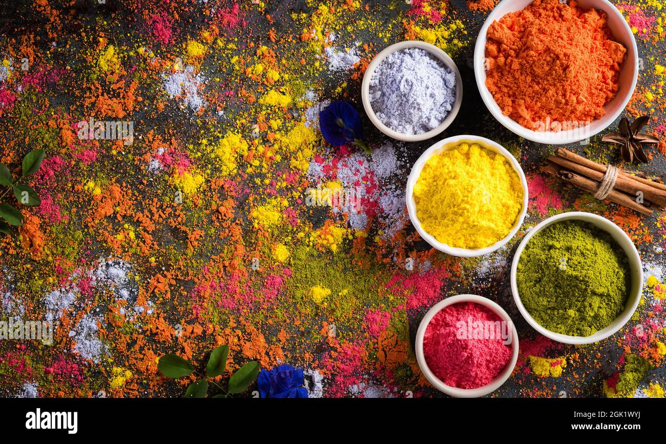 Holi-Festival-Feier. Traditionelle indische Holi Farben Pulverdekoration mit Farben. Draufsicht auf Organic Gulal Farben im Bowls Ondark Hintergrund. Stockfoto