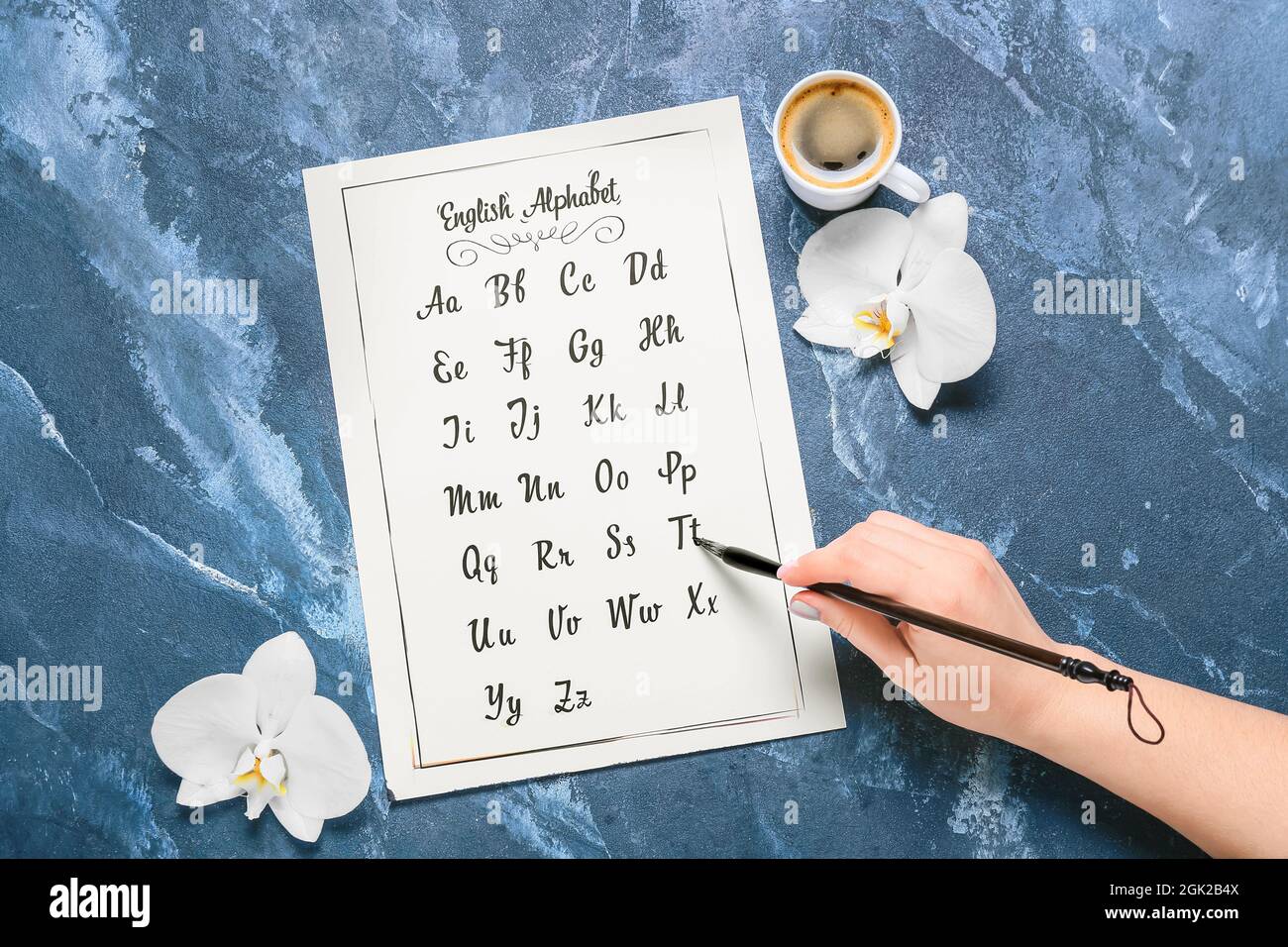 Frau mit kalligraphischen Pinsel Schrift Alphabet auf blauem Hintergrund Stockfoto