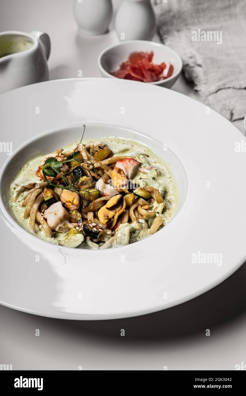 Nahaufnahme von Spaghetti mit Meeresfrüchten. Traditionelle italienische Pasta mit Garnelen, Muscheln und Tintenfisch mit einer würzigen Sauce. Mediterrane Küche. Vertikale Aufnahme Stockfoto