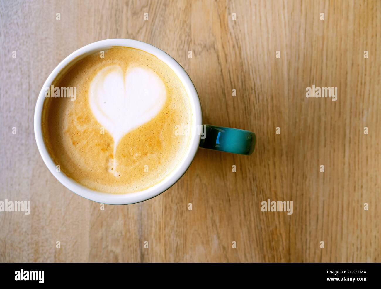 Kaffeegetränk mit Schaum, Latte oder Cappuccino. Keramikbecher mit Kaffee und Herzform, Draufsicht. Café-Innenausstattung Stockfoto